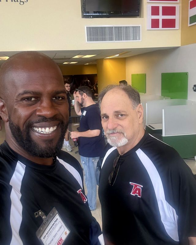 Two Team Avenue staff in team jackets smile at a University of South Florida event.